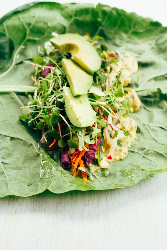 Collard green wrap with hummus and veggies lined up across the top. 