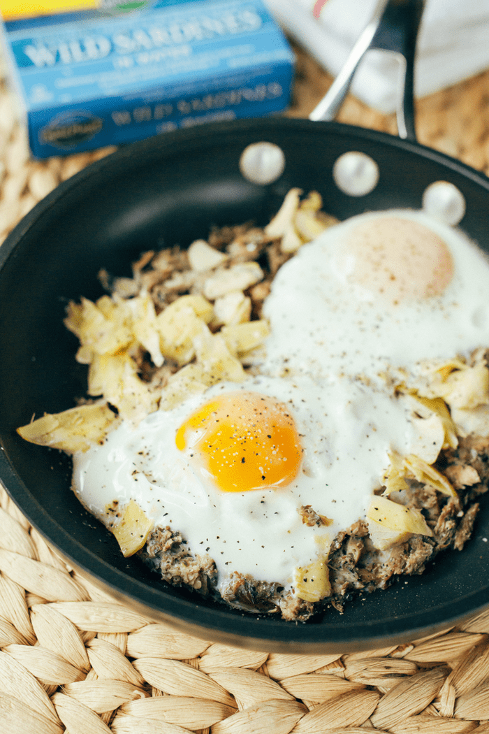 A quick and simple protein-packed paleo breakfast recipe with sardines, artichokes and eggs, baked and served over fresh arugula. 