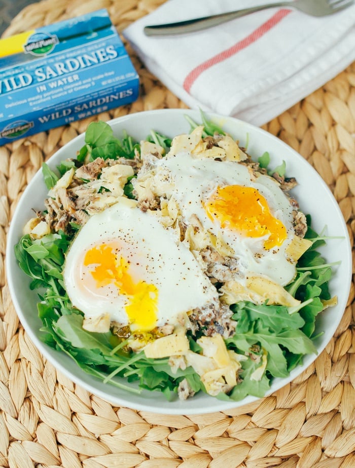 Seaside Breakfast Salad -- A quick and simple low-carb paleo breakfast recipe with sardines, artichokes and eggs, baked and served over fresh arugula. 