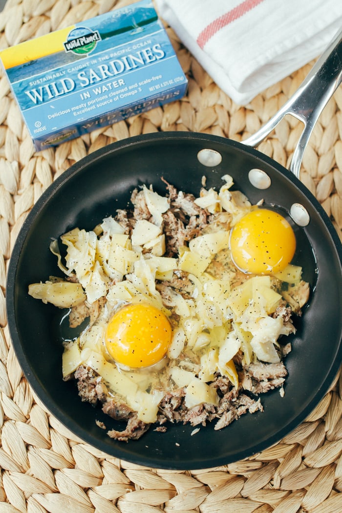 A quick and simple protein-packed paleo breakfast recipe with sardines, artichokes and eggs, baked and served over fresh arugula. 