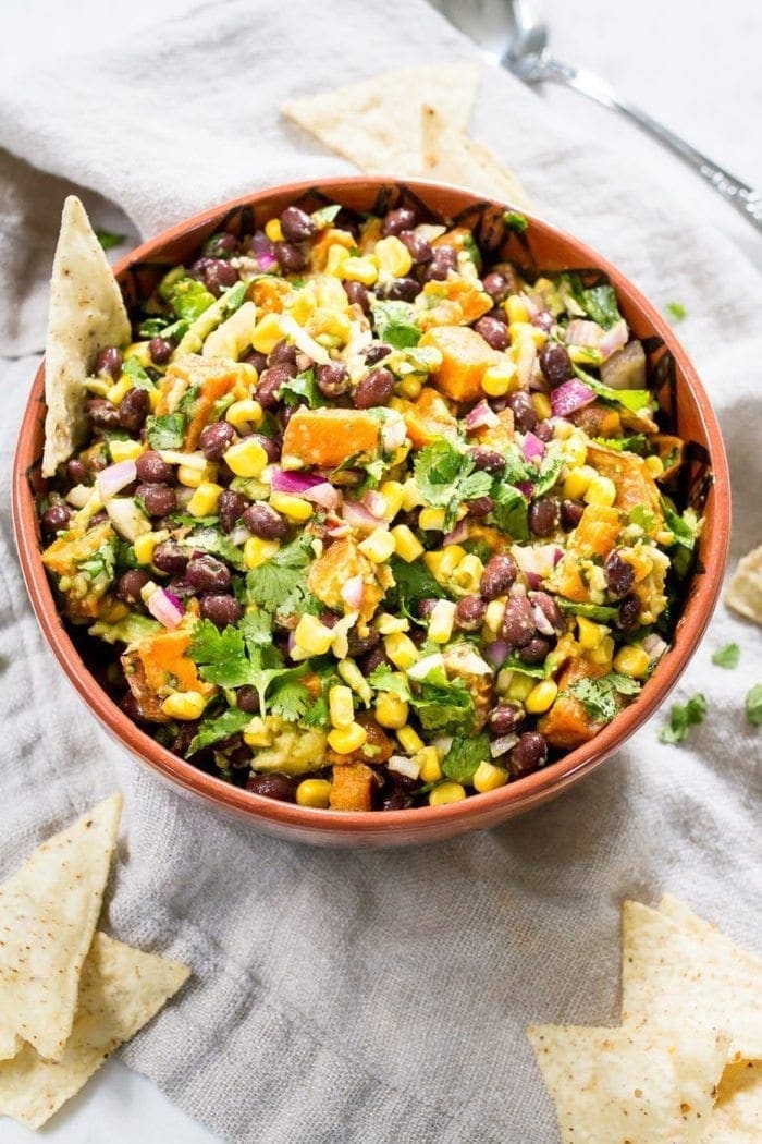 Southwest sweet potato black bean dip served in a mixing bowl with tortilla chips.
