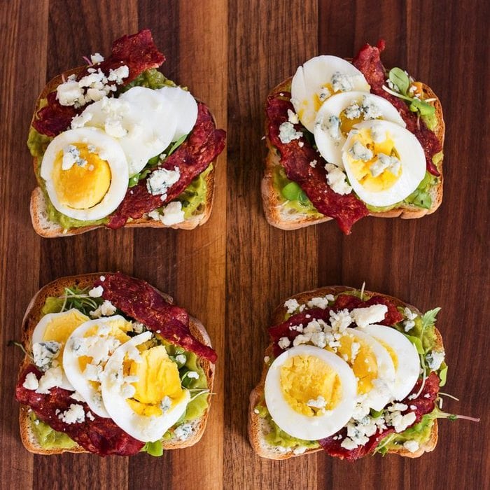 Birds eye view of four slices of Cobb salad avocado toast.