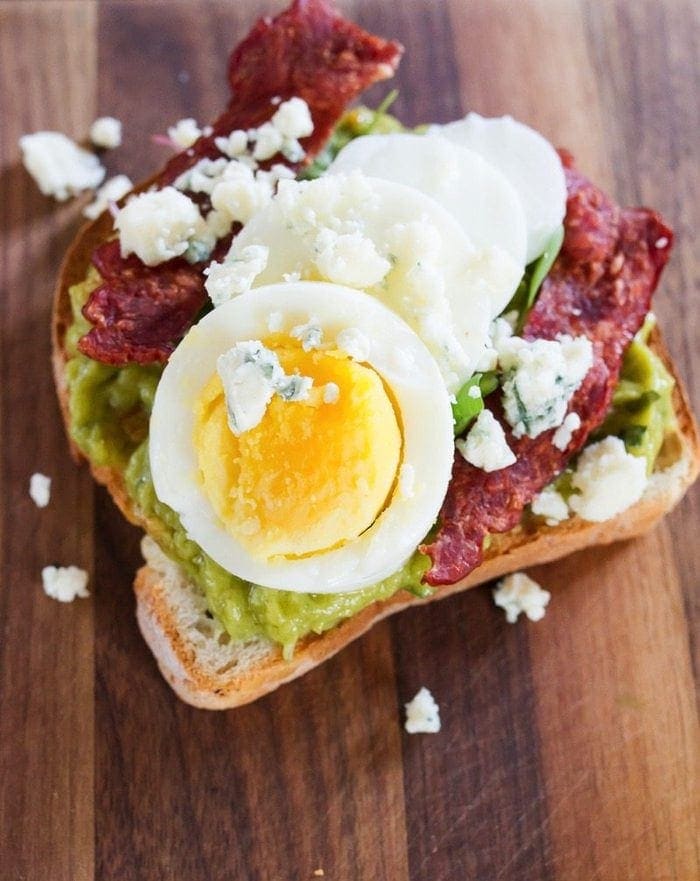 Close up shot of a slice of Cobb salad avocado toast.