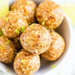 Key lime energy balls in a bowl garnished with lime zest.