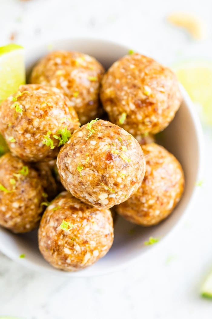 Key lime energy balls in a bowl garnished with lime zest.