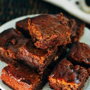 A plate with peanut butter hummus brownies stacked on top.