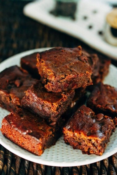 A plate with peanut butter hummus brownies stacked on top.