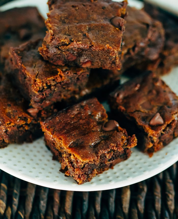 A plate with peanut butter hummus brownies stacked on top.