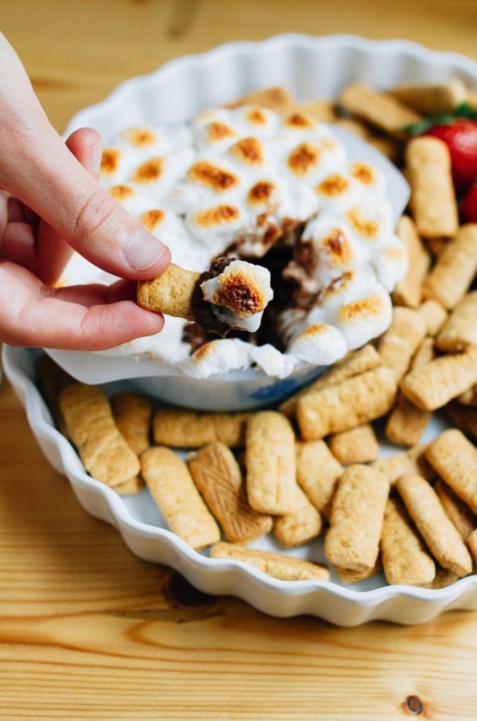 S'mores dip topped with toasted marshmallows. Dipped with gluten free graham cracker sticks.