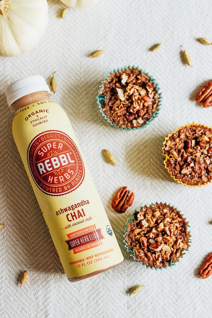 Chai oatmeal cups in cupcake liners on a table with spices and a bottle of Rebel chai.