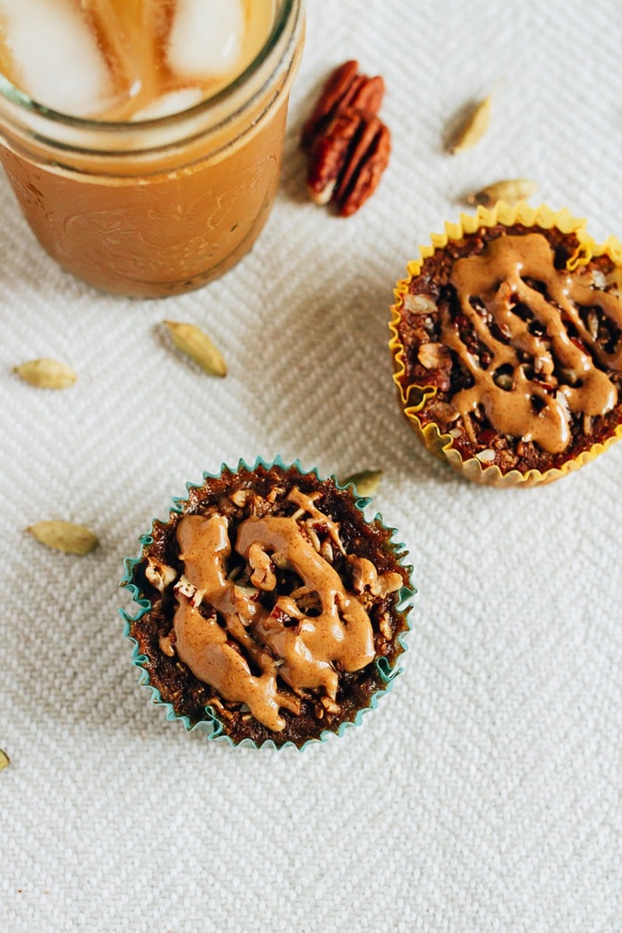 Baked chai oatmeal cups drizzled with peanut butter. A jar of iced coffee to the side.