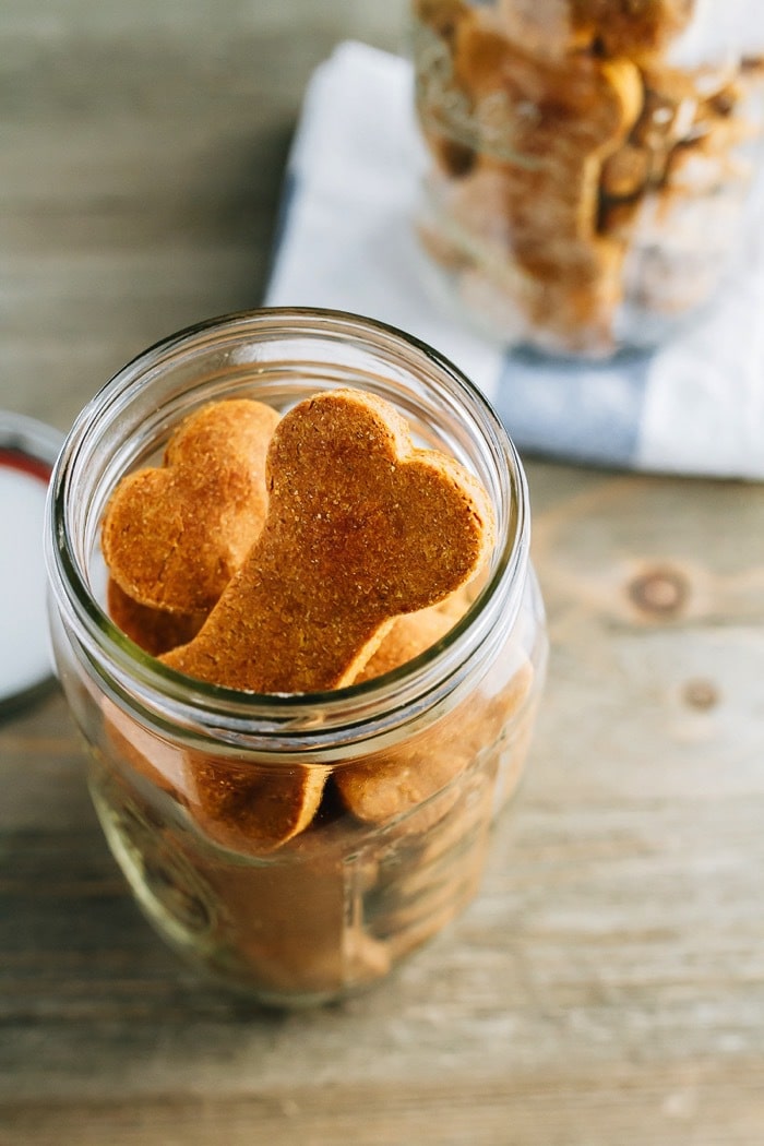 Overhead shot of homemade peanut butter and pumpkin dog treats in a clear mason jar.