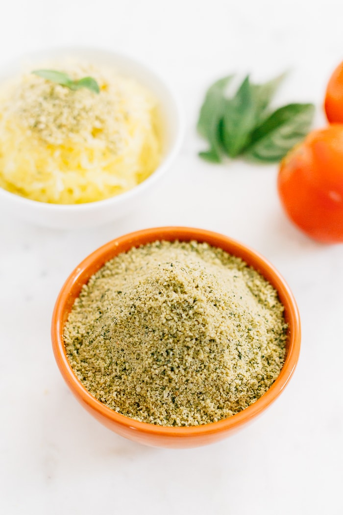 Make your own vegan parmesan cheese with hemp seeds. It’s the perfect cheesy topping for pizza, pasta, veggies, salads, popcorn and more. Vegan hemp parmesan in an orange bowl.