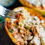 Fork taking a spoonful of spaghetti squash from a lasagna spaghetti squash boat.