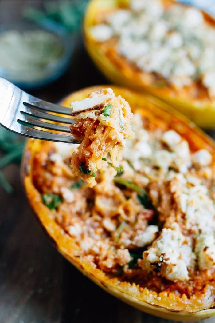 Fork taking a spoonful of spaghetti squash from a lasagna spaghetti squash boat.