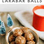 Bowl of gingerbread Larabar balls next to a mug of milk and Christmas tree decorations.