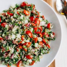 Shallow bowl filled with hemp heart tabbouleh made with hemp, cucumbers, herbs and tomatoes.