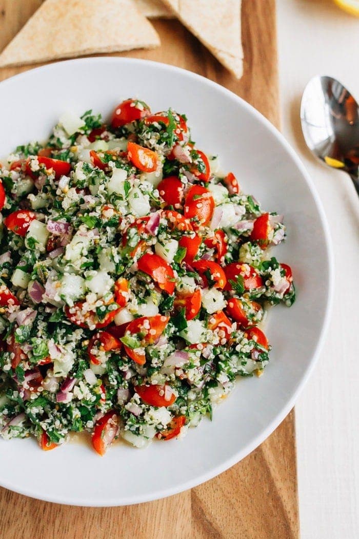 Shallow bowl filled with hemp heart tabbouleh made with hemp, cucumbers, herbs and tomatoes.
