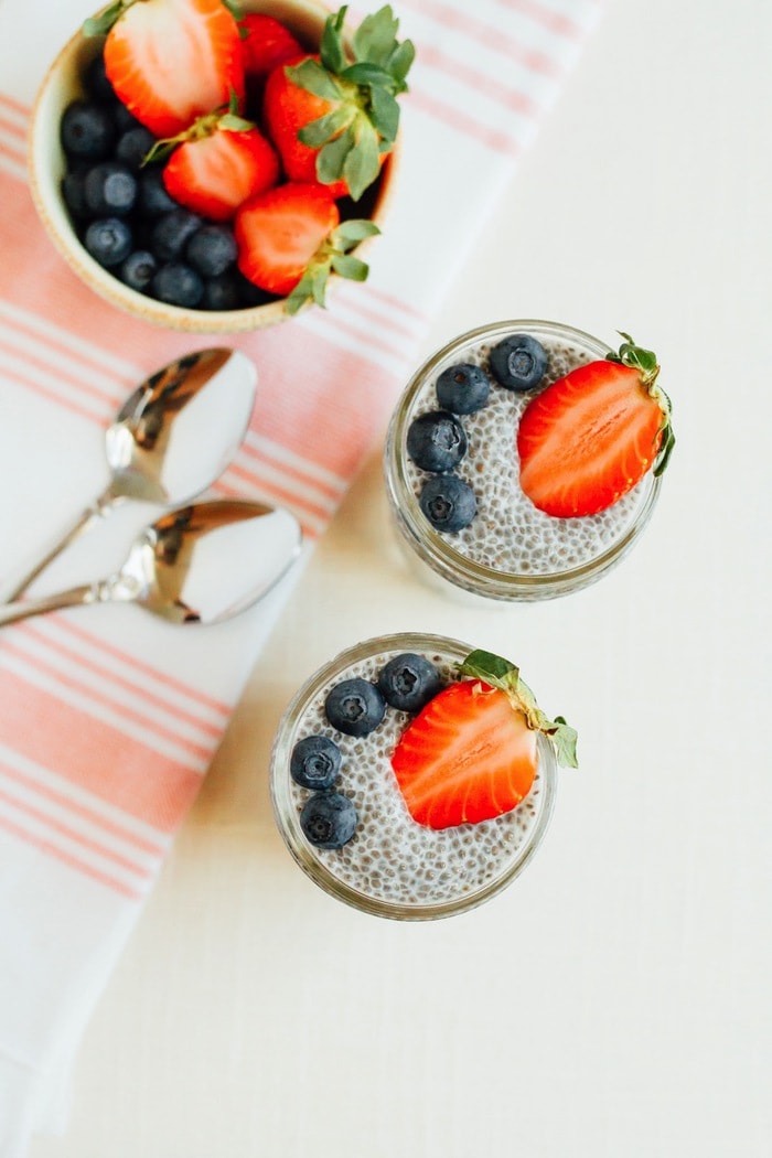 Chia pudding in small mason jars with berries on top.