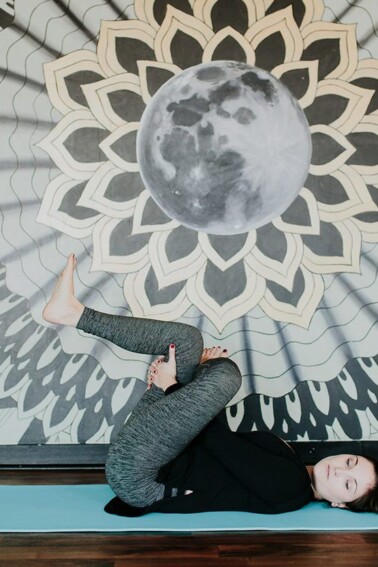 Woman stretching legs on yoga mat.