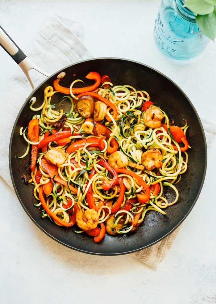 Cooked shrimp and zucchini noodle lo mein in a large skillet. 