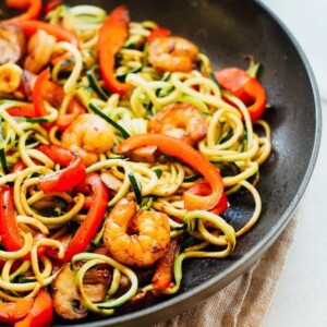 Zucchini noodles, mushrooms, shrimp, red pepper lo mein in a pan.