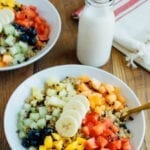 Cinnamon quinoa in a bowl, topped with chipped fruit and cacao nibs.