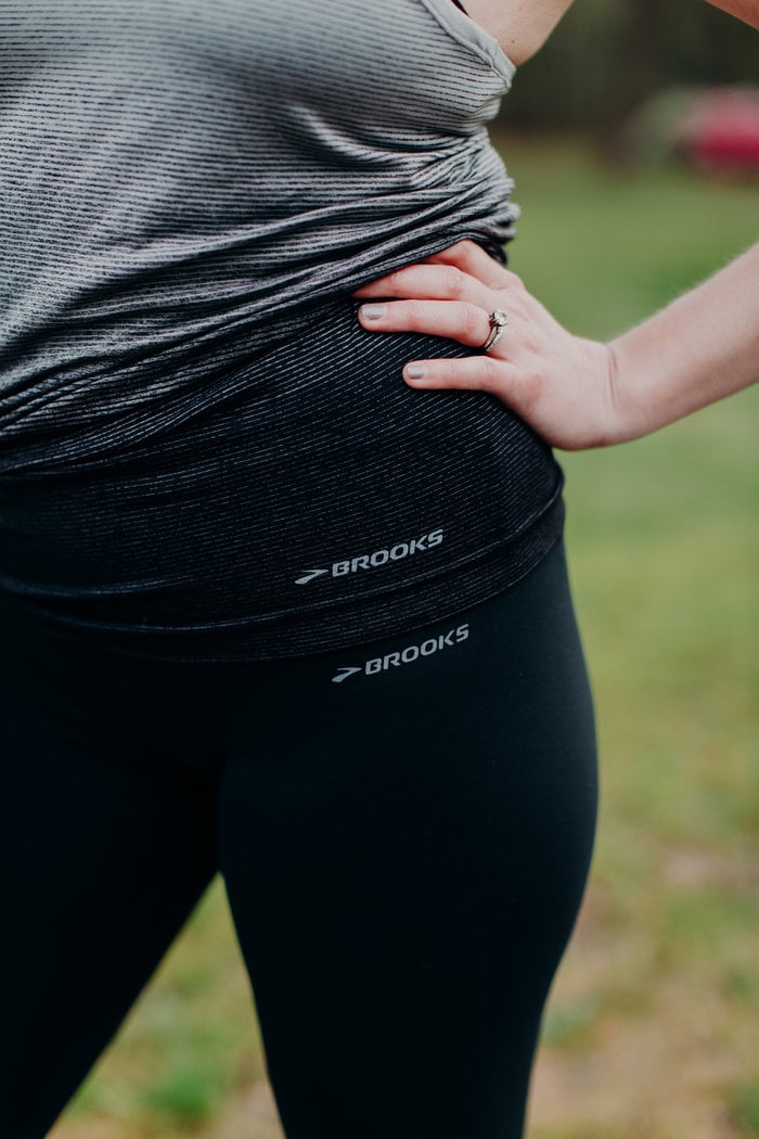 Detail of a woman's hip focusing on a Brooks logo.