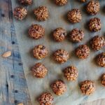 View from above of chocolate almond crispy bites on parchment on a wooden table.