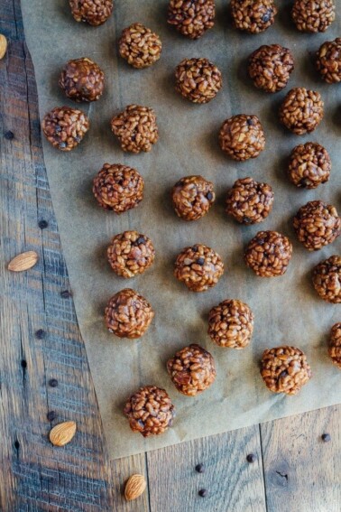 View from above of chocolate almond crispy bites on parchment on a wooden table.