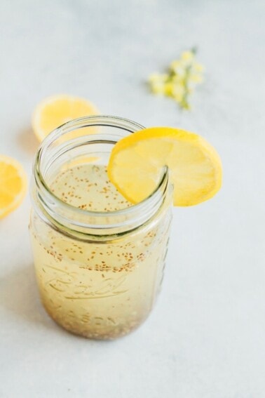 Mason jar of lemon chia fresca with a lemon garnish.