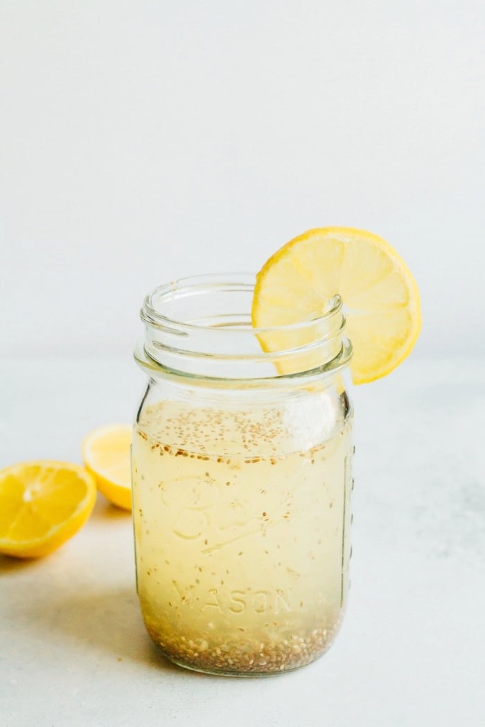 Lemon Chia Fresca in a clear mason jar with a slice of lemon. 