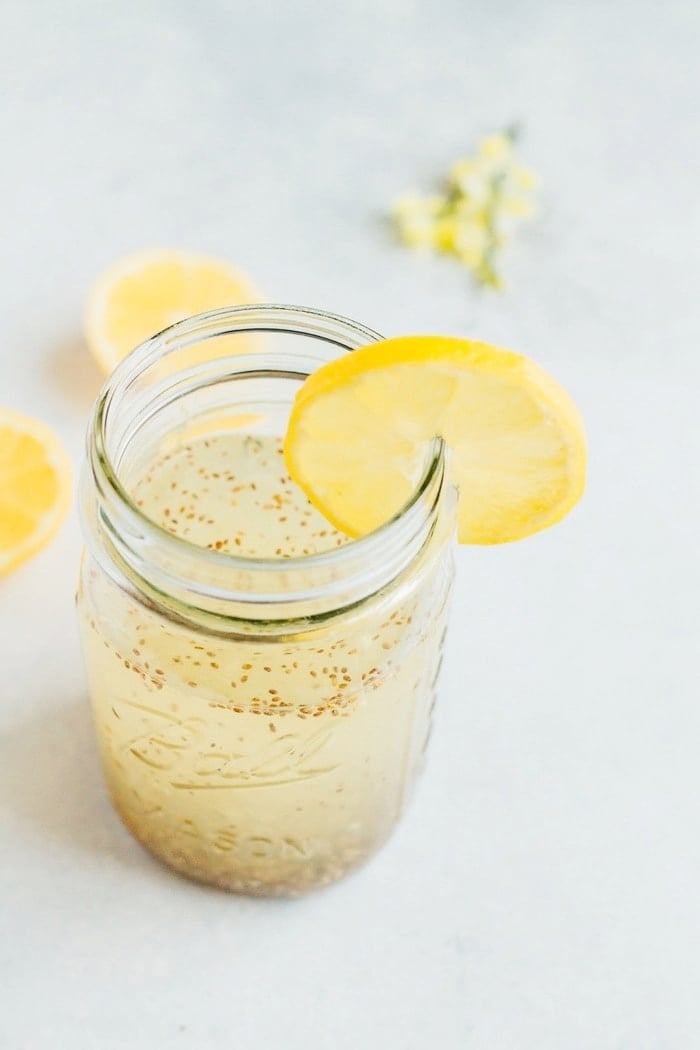 Lemon Chia Fresca in a clear mason jar with a slice of lemon. 