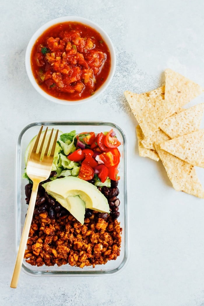 Tempeh Taco Salad Meal Prep Bowls with tempeh taco meat, black beans, tomatoes, onions and avocado