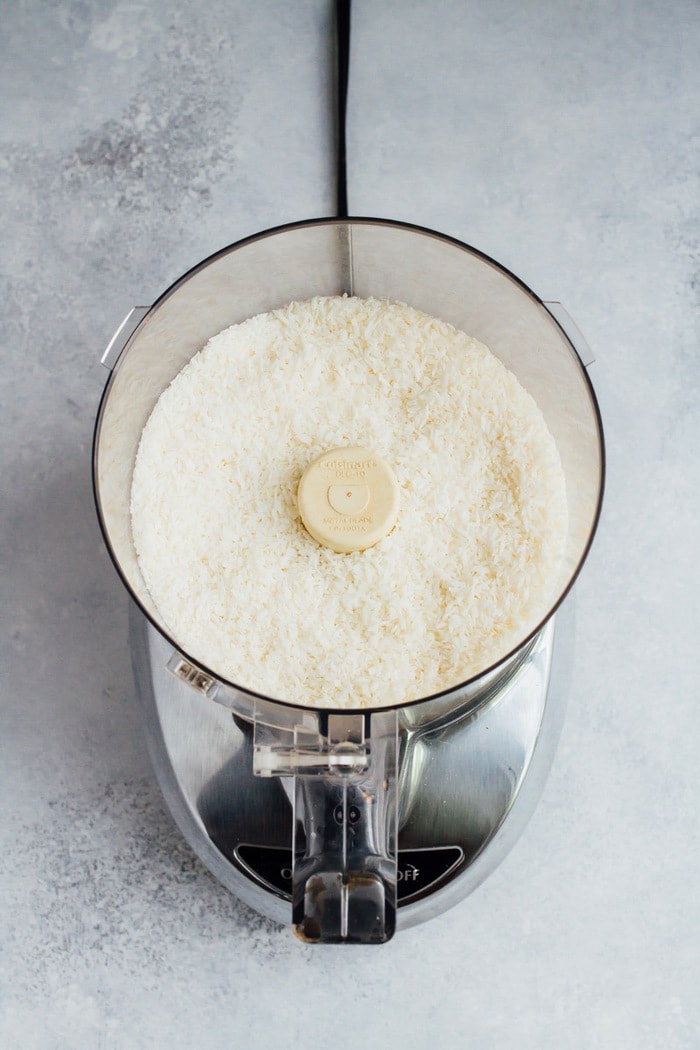 Shredded coconut in the food processor getting ready to be turned into coconut butter. 