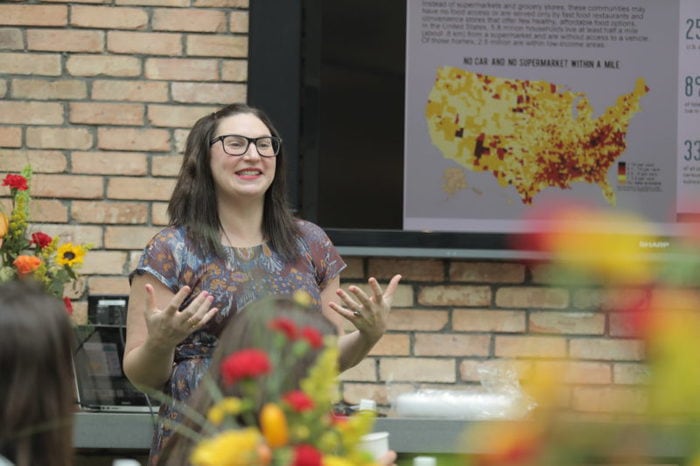 A woman speaking outside with her hands.