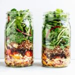 Layers of black bean fiesta mason jar salad, in two jars.