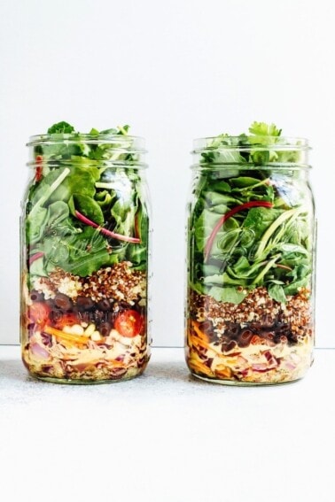 Layers of black bean fiesta mason jar salad, in two jars.