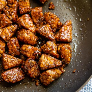 Marinated tempeh finished cooking in a large skillet.