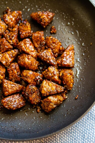 Marinated tempeh finished cooking in a large skillet.