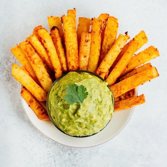 Plate with baked jicama fries and a bowl of guacamole.