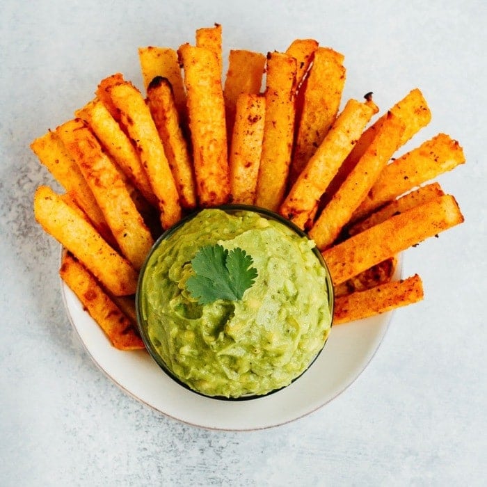 Plate with baked jicama fries and a bowl of guacamole.