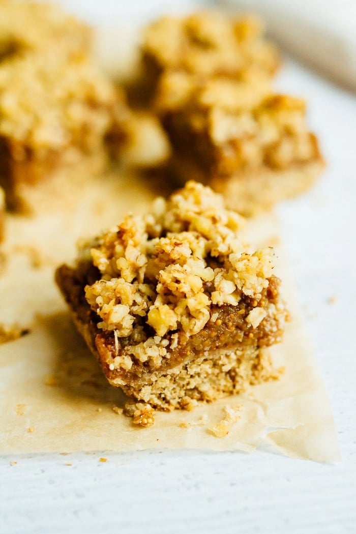 Close up of a fig crumble bar on parchment.