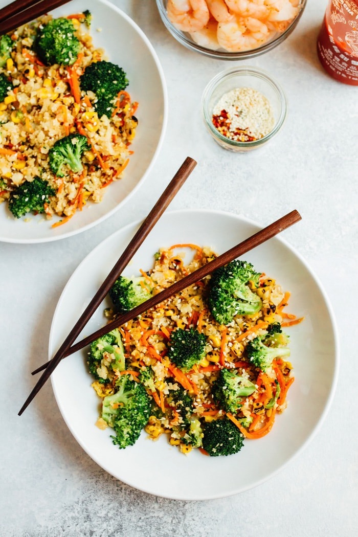 Two bowls of cauliflower fried rice with chopsticks.