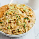 Bowl of zucchini bread oatmeal with walnuts and grated zucchini.