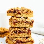 Stack of four pb&j bars. Bars filled with jam, topped with peanut butter crumble.