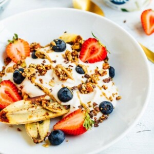 Yogurt bowl with banana, strawberries, granola, and nut butter.