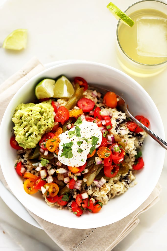 Veggie burrito bowl with cauliflower rice and sunflower sour cream in a white serving bowl.