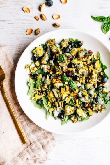 Blueberry Eggs Breakfast Salad with basil and pistachios on a plate.