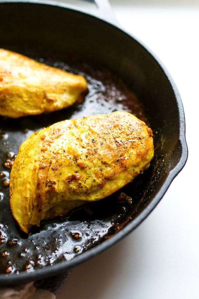 Maple turmeric chicken fully cooked in the cast iron skillet.